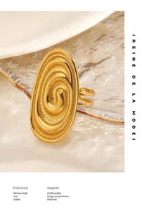 Detail of golden chunky oval ring with spiral vortex texture on transparent glass