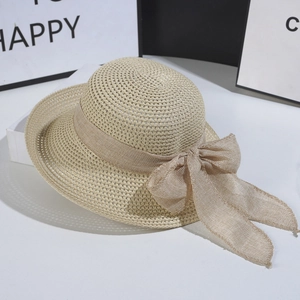 Foldable women's sun straw hat with wide brim and large bow ribbon in light khaki