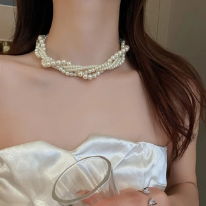 Elegant multi-layer pearl necklace with vintage twisted design worn by a model