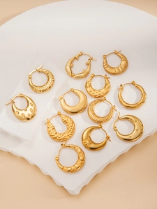 Detailed close-up of various gold-plated titanium steel earrings with textured patterns