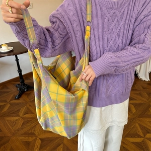 Macro shot of colorful checkered canvas tote bag showing metal buckle detail and texture