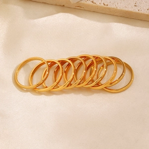 Set of 8 minimalist gold stainless steel plain bands on beige silk background