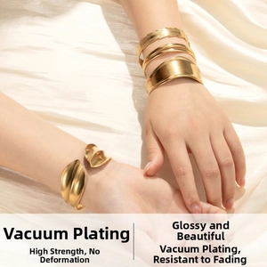 Detailed view of textured gold cuff bracelets with leaf and braided patterns on silk