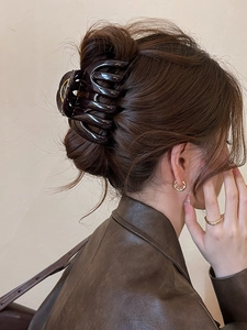 Detail view of a large tortoiseshell acrylic hair claw clip styled on a woman's updo