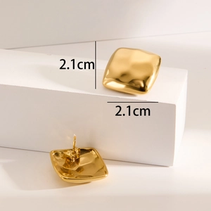Detail shot of square gold plated earrings with hammered metal texture and 2.1cm dimensions
