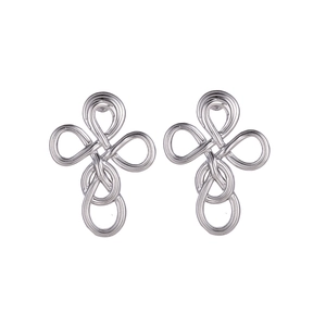 Macro detail of silver woven cross stud earrings with polished metallic texture
