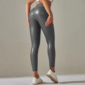 Macro detail of high-waisted dark grey faux leather leggings with glossy texture