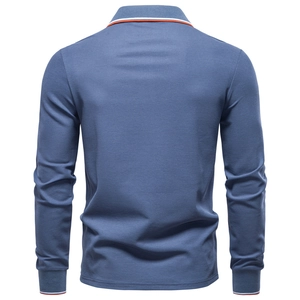 Detail view of long-sleeve blue polo shirt back with orange striped cuffs and collar trim