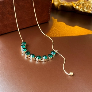 Dettaglio macro della collana a maglia serpente placcata oro con zirconi verdi