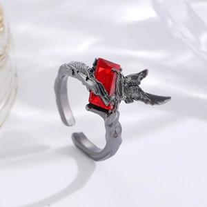 Macro shot of adjustable crow thorn ring with a red rectangular gemstone and dark metal wings