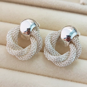 Polished silver 18K plated vintage style camellia woven hoop earrings on beige velvet