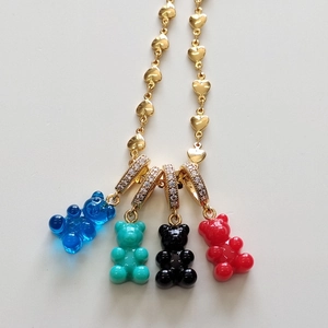 Detail of colorful resin gummy bear pendants with rhinestone accents on a gold heart chain