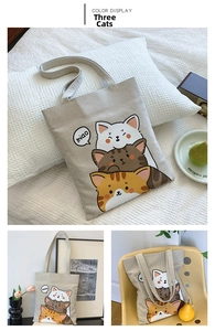 Close-up of beige canvas tote bag featuring cute cartoon three cats graphic print