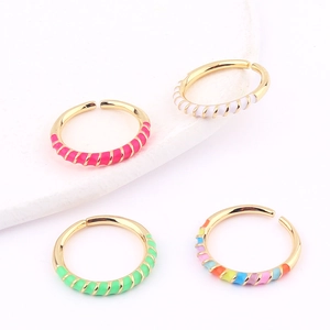 Detail of colorful enamel spiral open rings in gold finish with textured twist design
