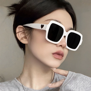 Weiße quadratische Sonnenbrille mit schwarzen Gläsern und Herz-Detail am Bügel