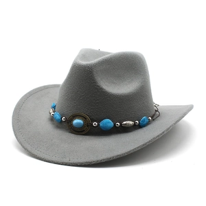 Detail of grey felt cowboy hat with turquoise beads and vintage metal disc on band