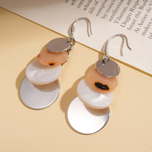 Detail shot of boho acrylic drop earrings featuring silver metal and orange resin discs