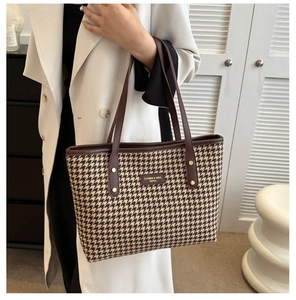 Brown houndstooth tote bag shown in a 45-degree angle on-shoulder model view