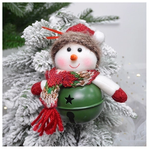 Detail of Christmas snowman bell ornament with white plush and red knit hat on pine branch