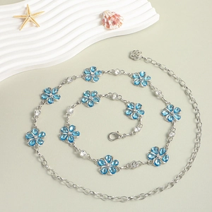 Detailed macro view of silver waist chain with blue flowers, rhinestones, and lobster clasp