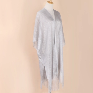 Detail shot of silver sparkling fabric texture with elegant tassels on the shawl edge