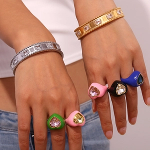 Close-up of colorful heart-shaped resin rings and gold-plated bracelets on model