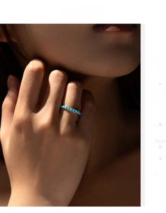 Dettaglio dell'anello in argento 925 con file di turchesi indossato, stile minimalista