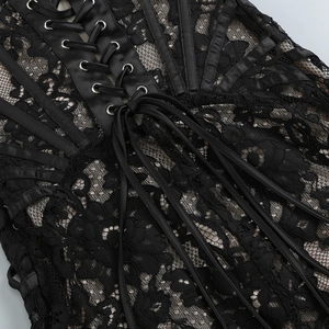 Détail de la robe en dentelle noire avec œillets métalliques et laçage en satin
