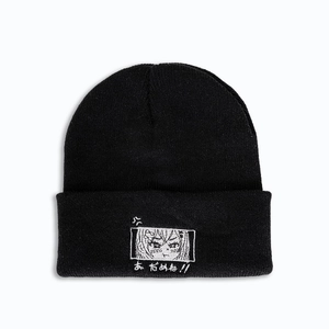 Détail du bonnet en maille noire avec broderie de fille de dessin animé blanc