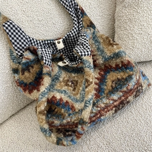 Detail of bohemian plush tote bag showing inner gingham lining and secure metal snap closure