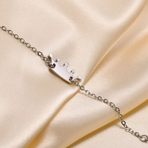 Macro shot of silver crown pendant on a fine O-chain with polished steel finish