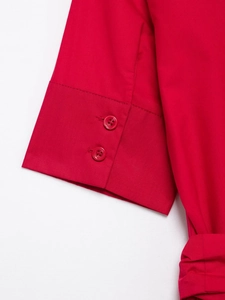 Detail of red shirt dress cuffs featuring two matching buttons on smooth poplin fabric