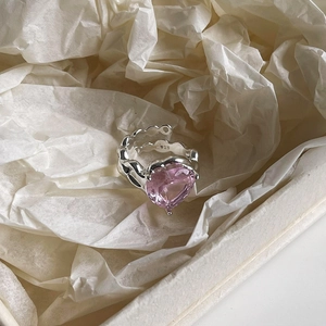Macro view of S925 silver ring featuring a pink heart-shaped crystal and wavy metal texture