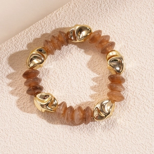 Detail of amber resin beads and irregular gold alloy metal charms on a vintage bracelet