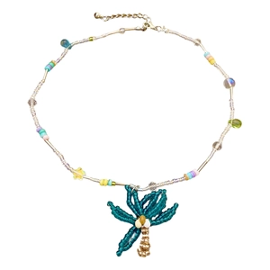 Close-up of handmade palm tree pendant with colorful beaded summer beach necklace