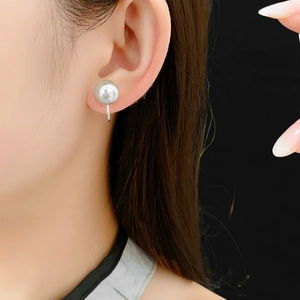 Close-up of a large grey pearl ear cuff on model ear with silver U-shaped metal clip