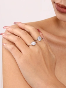 Close-up of elegant silver rings with oval zircon on a model's hand and shoulder