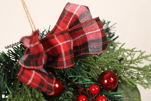 Close-up of Christmas eucalyptus ornament with red berries and plaid bow detail
