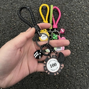 Close-up of colorful woven rope keychains featuring Monte Carlo poker chip charms and dice