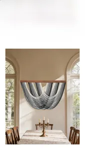 Détail d'une tapisserie en coton gris dégradé avec perles en bois dans une salle