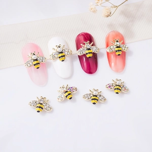 3D bee nail art charms with pearls, rhinestones and yellow enamel on manicured nails
