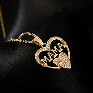 Gold-plated MOM heart necklace with cubic zirconia on a dark leather background