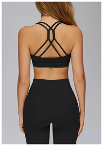 Detail view of the crisscross back straps on a black yoga bra with matching leggings
