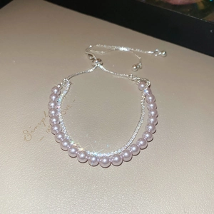 Detail of double-layer bracelet with soft pink pearls, crystals, and adjustable silver chain