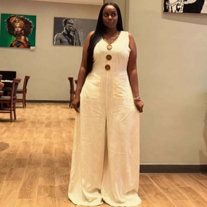 Beige sleeveless wide-leg jumpsuit with large brown button details on cotton-linen fabric