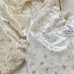 Detailed macro view of pearlescent velvet fabric with cute bear and floral prints