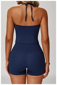 Detail of navy blue backless halter yoga top and high-waisted shorts on fitness model