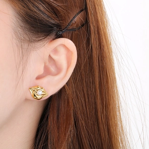 Close-up of elegant gold irregular wrinkled earring featuring a lustrous round pearl