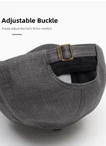 Detail view of adjustable metal buckle and dark grey twill fabric on back of the baseball cap