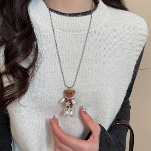 Detail of brown flocked bear necklace with pearl and star charm on stainless steel chain